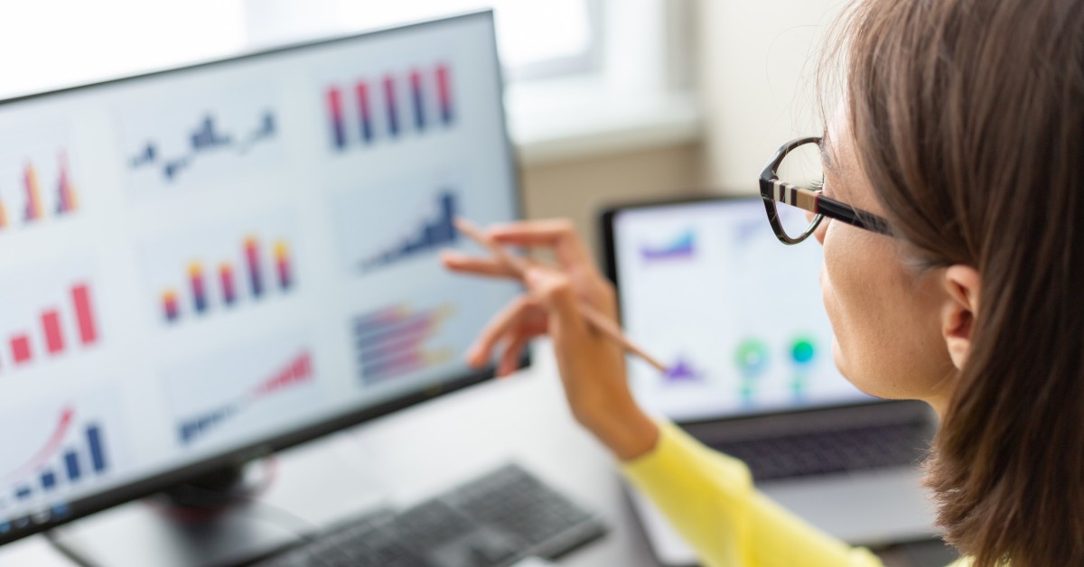 A marketer looks over analytics data on a screen.